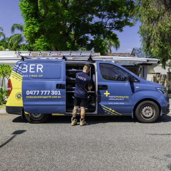 Ember Plumbing Perth tradie accessing tools from a branded service van parked outside a suburban home in Perth